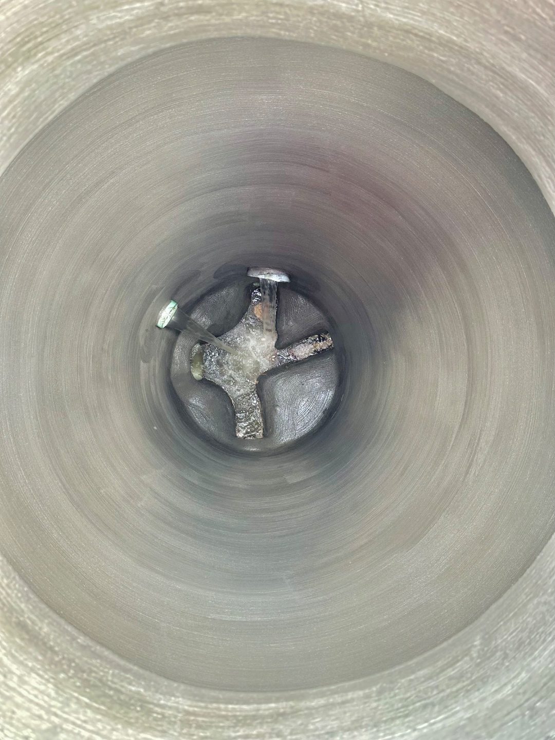 Same sanitary manhole after CEI rehabilitation with rebuilt bench, restored invert channels, and full corrosion-resistant coating